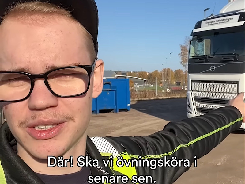 Ung kille framför lastbil